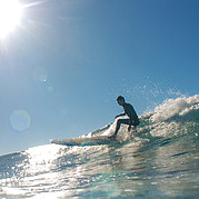 surfer maakt een vloeiende cutback op een lange, gladde golf met een klassiek longboard