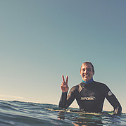 lachende surfer op het strand na het surfen van een mooie golf tijdens een surfles