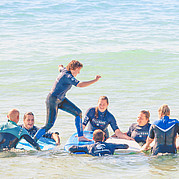 ouders en kinderen doen samen leuke en actieve spelletjes met een surf-thema op het strand