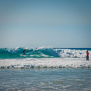 surfer oefent een backside cutback terwijl hij live instructies ontvangt via een helm met radioverbinding
