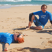 surfstudent glimlacht vermoeid na een intensieve dag surfen in de zon