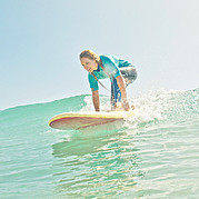 surfer staat op zijn board tijdens de take-off op een ongebroken groene golf
